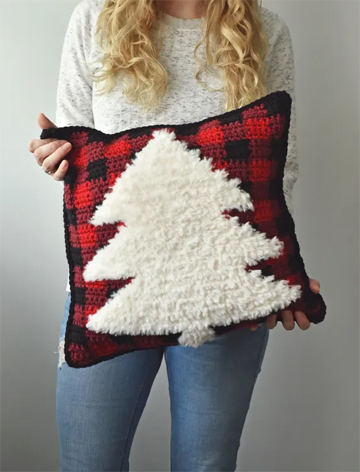 Red and black plaid pillow with white faux fur Christmas tree