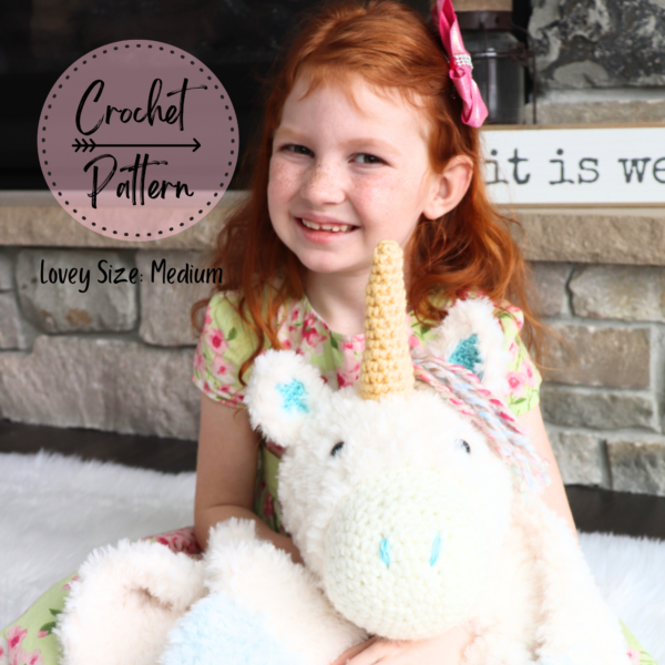 Girl holding medium crochet unicorn lovey