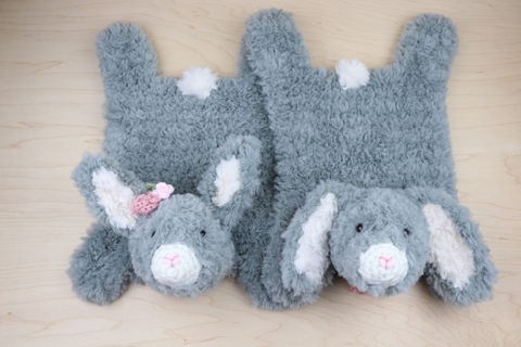 Two crocheted bunnies, one with pointed ears and one with floppy ears.