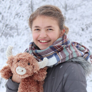 Picture of woman holding a highland cow in the winter