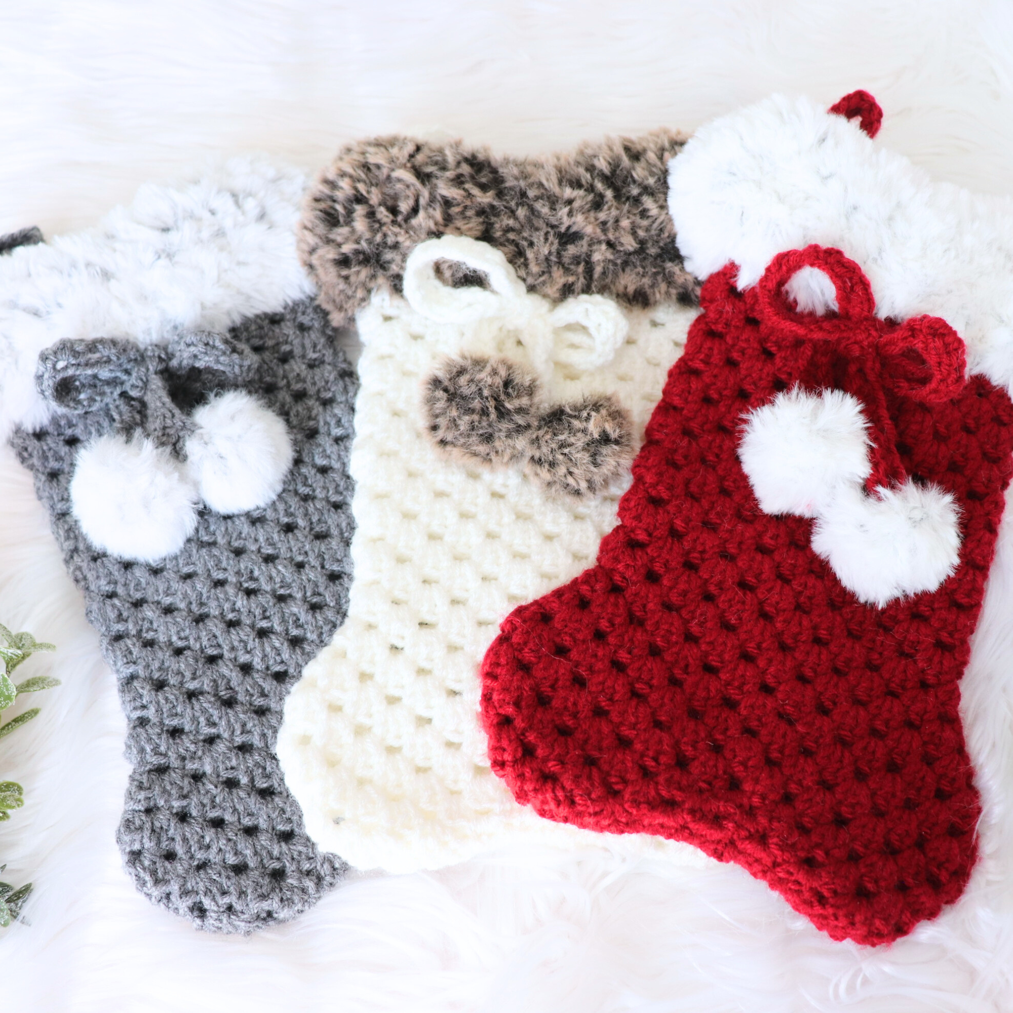 3 crochet dog bone stockings laying on desk