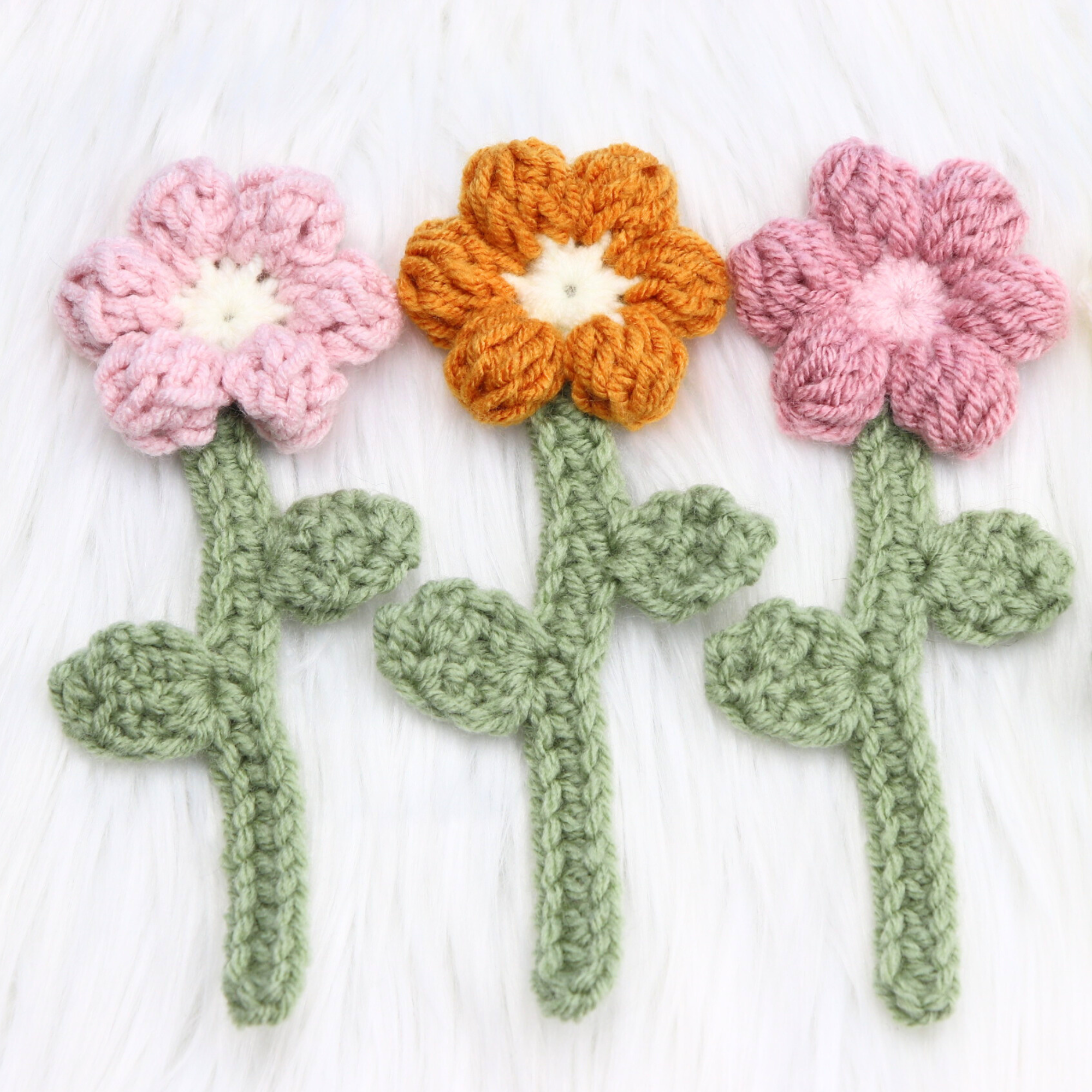 3 crochet flower bookmarks on desk